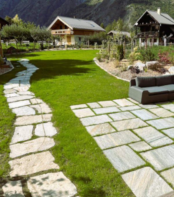 Une belle pelouse verte avec une terrasse en dalles de pierre, jardin de montagne à Serre-Chevalier